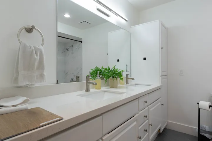 Dual vanity with integrated sinks, brushed nickel faucets, and under-counter storage