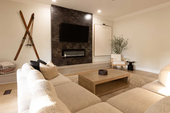 Accent wall with integrated linear fireplace, wood-finish flooring, recessed lighting, crown molding, and substantial baseboards