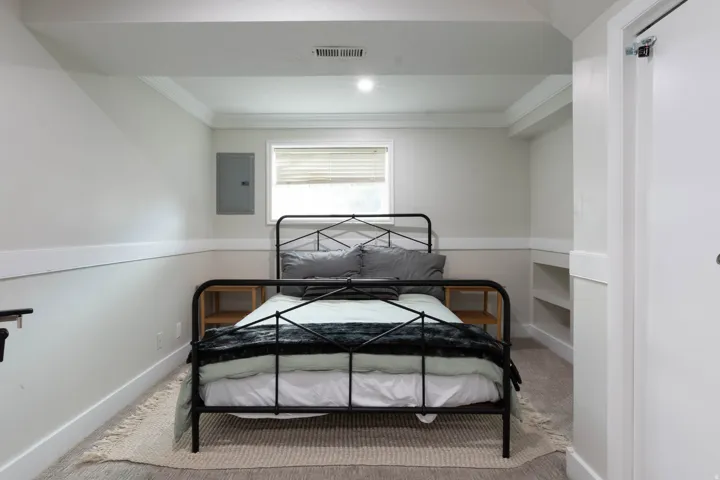 Recessed lighting, crown molding, built-in shelving, carpet flooring, and a single window with blinds