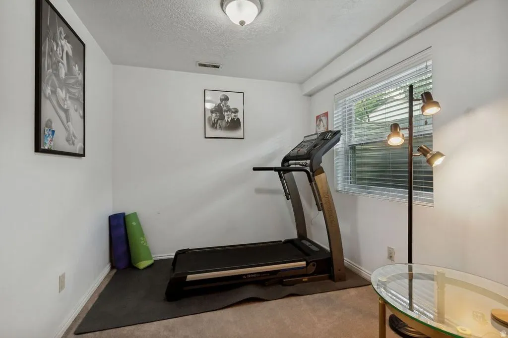 Recessed ceiling light fixture illuminates this room featuring white walls and a window with blinds