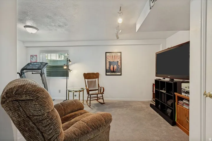 Carpeted flooring with white wall finishes, recessed ceiling light fixtures, and a single window with horizontal blinds