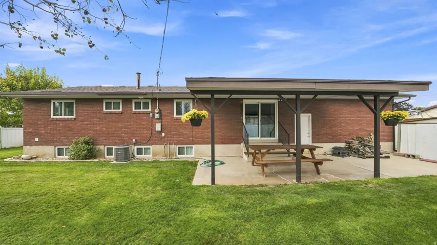 Brick ranch home with expansive rear yard featuring mature landscaping and level lawn