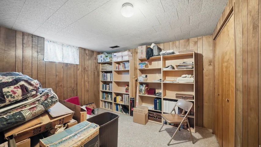 Basement bedroom with paneled walls.