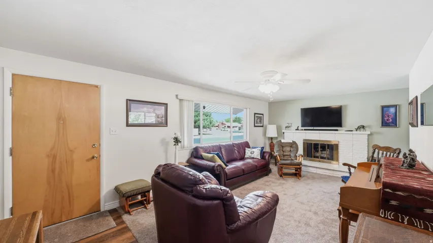 Spacious living room featuring plush seating arrangements, wood-finish flooring, and a fireplace.