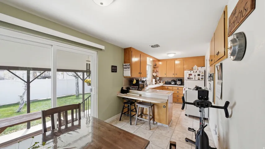 Kitchen with wood cabinetry, light countertops.