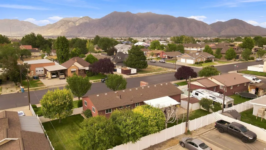 Residential neighborhood featuring mature trees and a distant mountain landscape