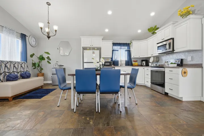 Kitchen featuring white cabinetry, stainless steel appliances, and a mosaic tile backsplash