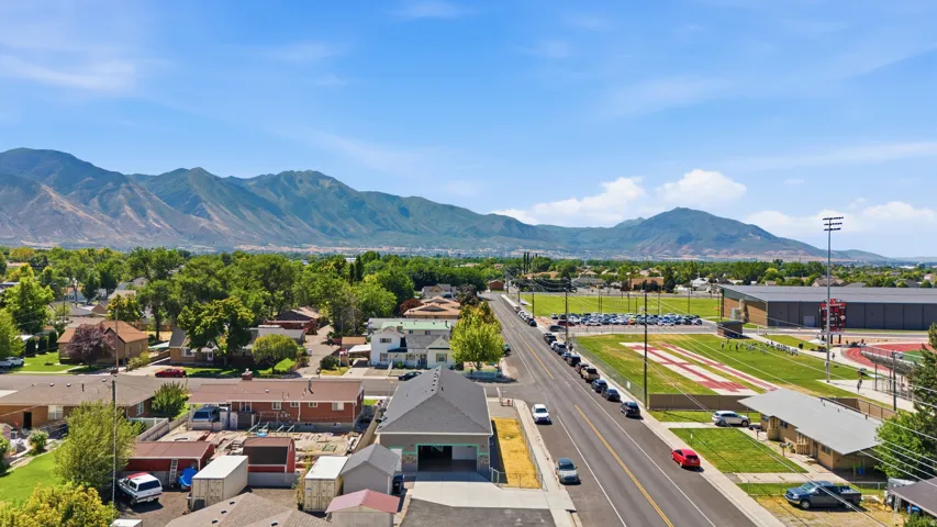 Mountain backdrop, mature trees, residential streetscape, and recreational fields