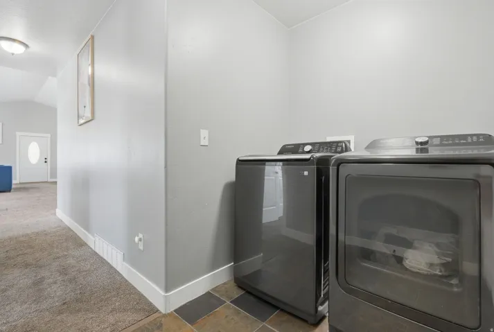 Laundry area featuring a tile floor, light gray wall paint, and white trim