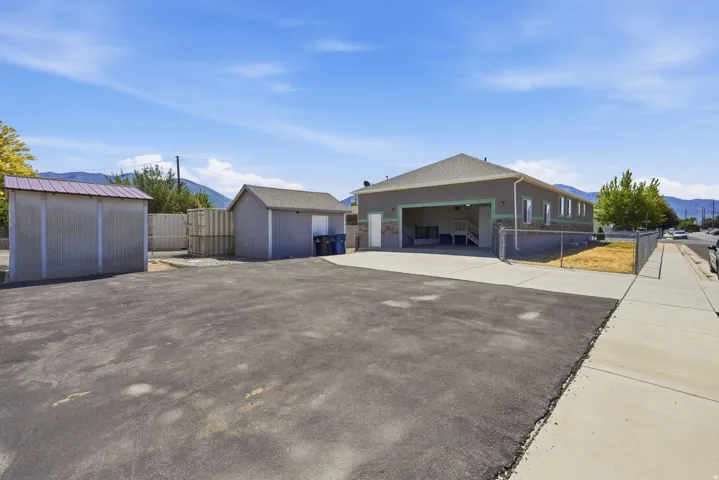Expansive paved lot with a detached shed and a separate storage structure