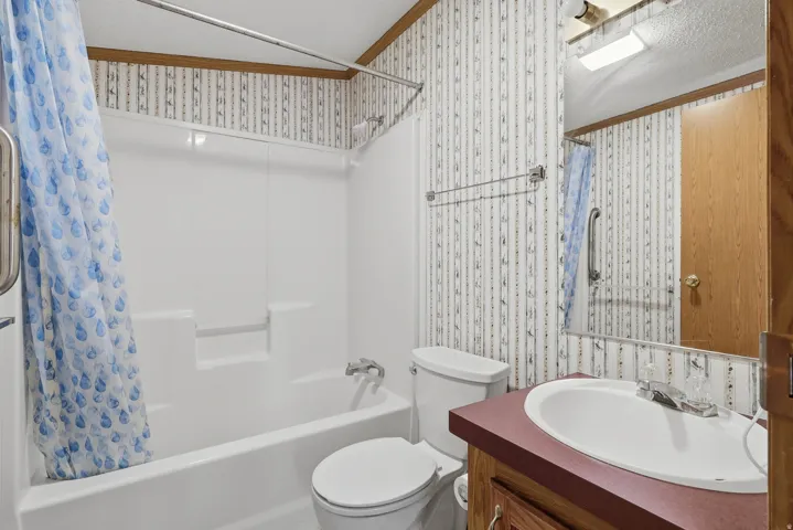 White tub and shower combination with chrome fixtures