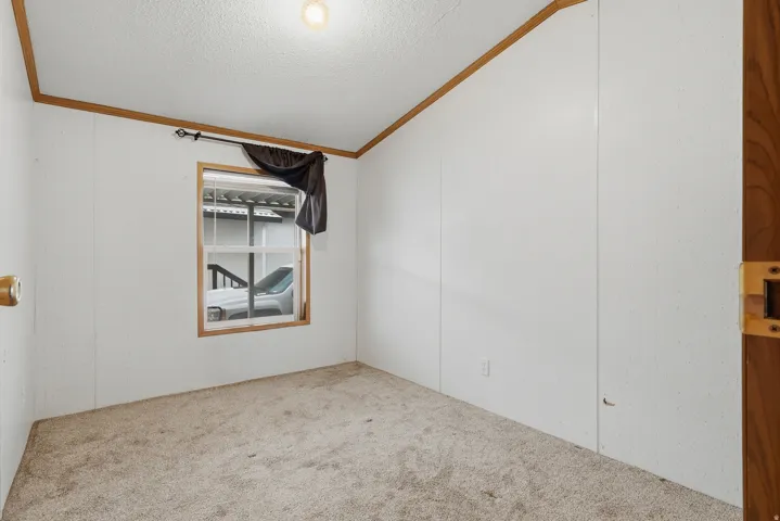 Recessed window with wood-finish trim, overhead lighting, and carpeted flooring