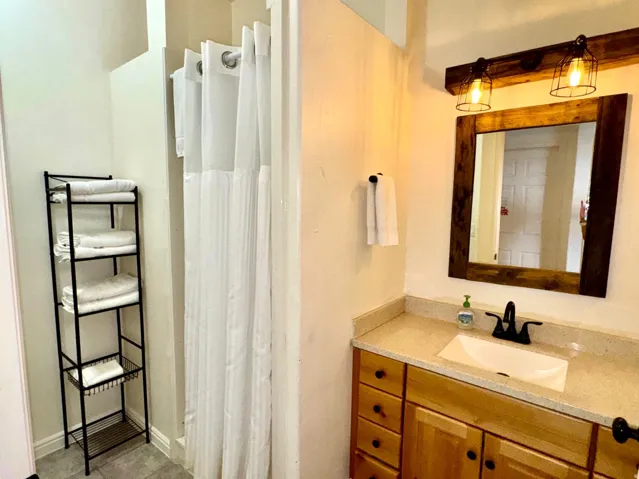 Bathroom featuring a vanity with wood cabinetry, light-toned countertop, and an undermount sink