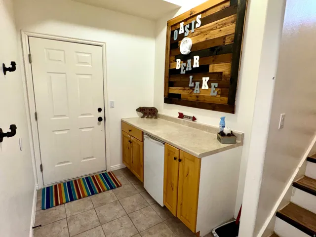 Tile flooring, built-in cabinetry with wood-finish doors, solid-surface countertop, and a solid white door