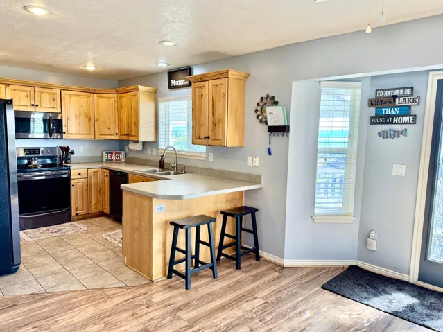 Well-appointed kitchen featuring wood cabinetry, stainless steel appliances, and a breakfast bar