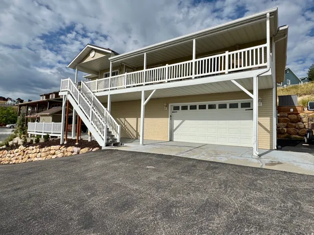 Multi-level exterior with a broad covered balcony and an attached garage