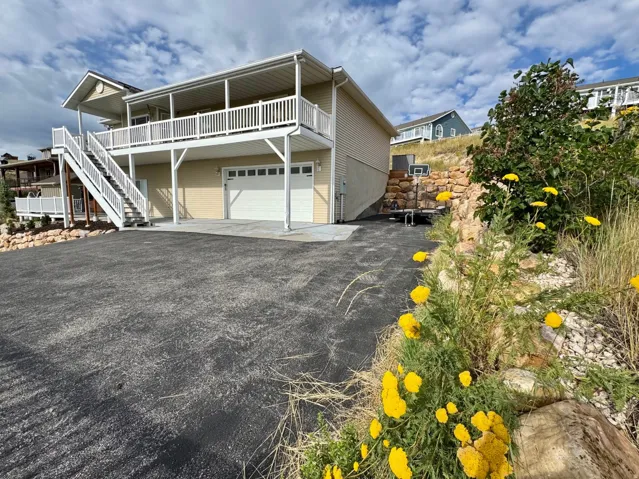 Two-story property with a lower-level garage, covered upper balcony, and exterior staircase