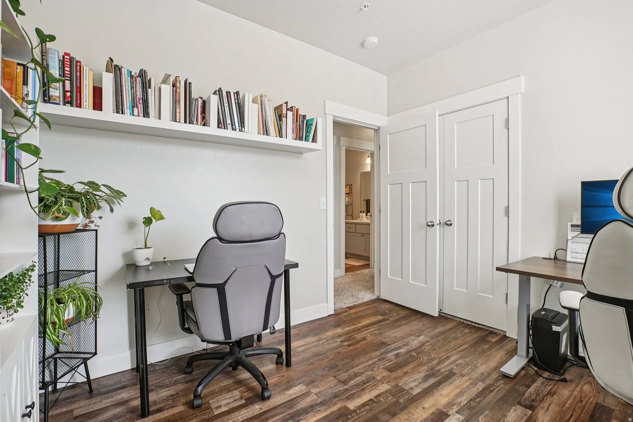 Room featuring wood-finish flooring, white walls, and built-in shelving
