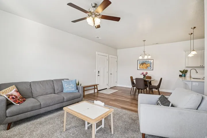Recessed lighting, ceiling fan with light fixture, wood-finish flooring, white cabinetry, and pendant lighting