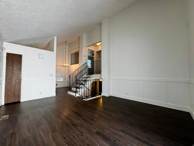 Dark wood-finish flooring with white wainscoting and trim