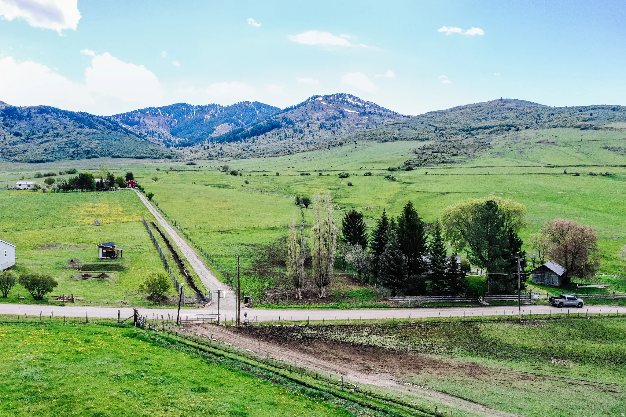 Expansive property featuring a winding driveway, mature trees, and mountainous terrain