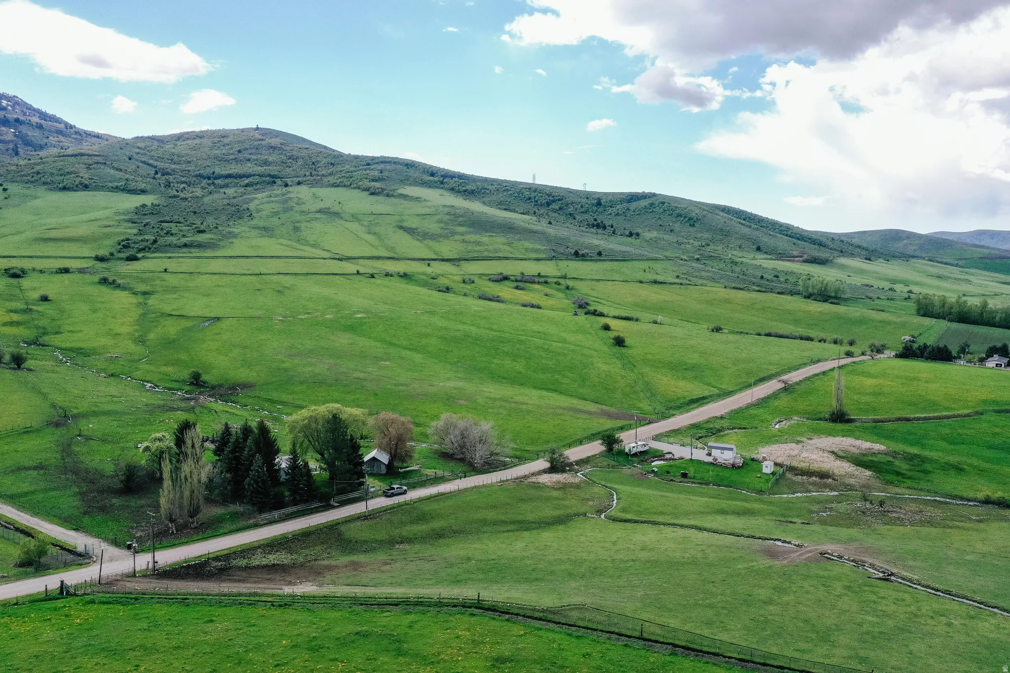 Expansive green landscape featuring rolling hills and distant mountains