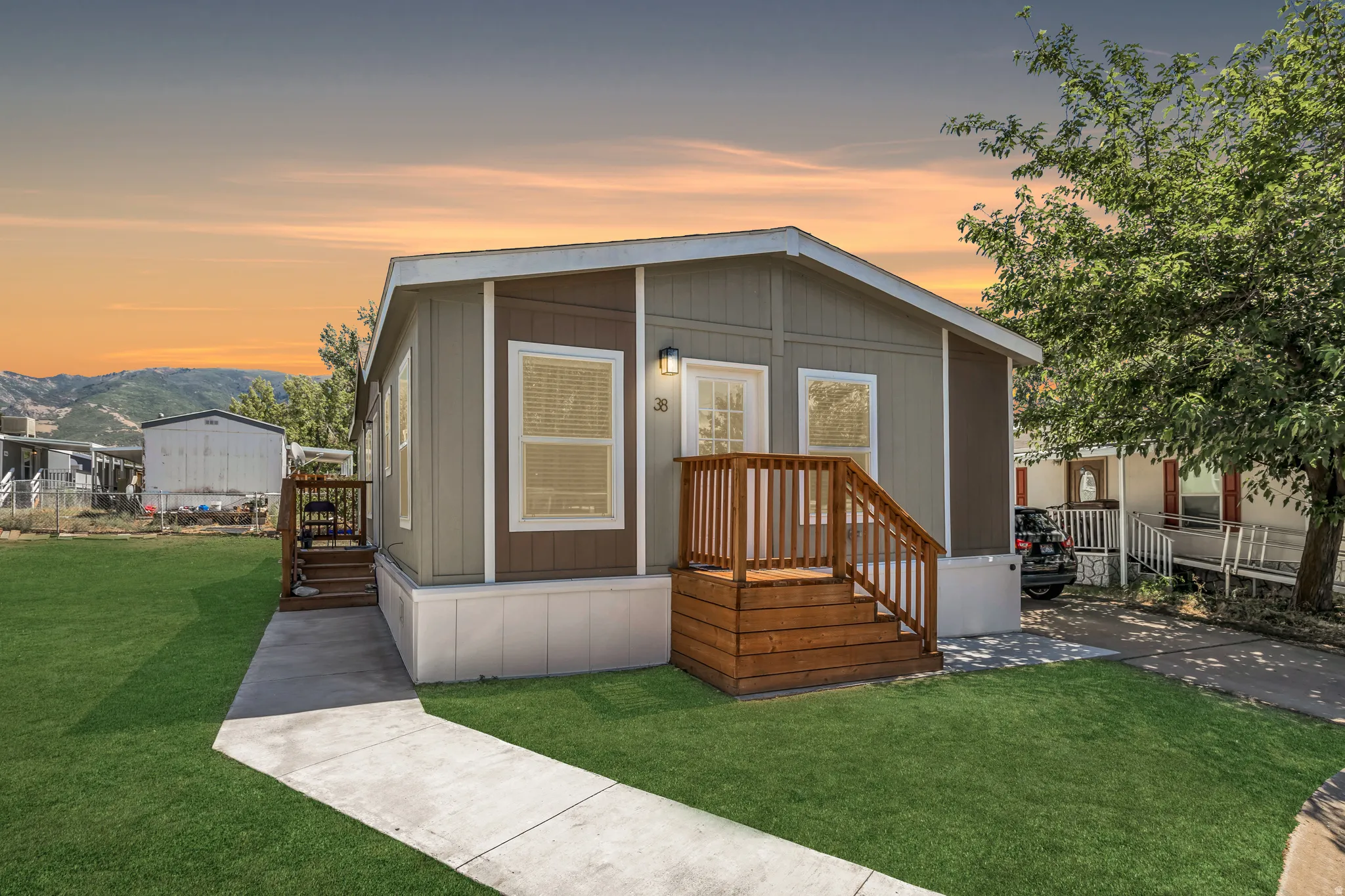 Exterior featuring two-tone siding, a wood-finish porch with railings, and a concrete walkway