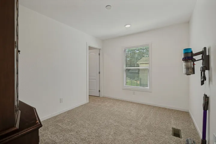 Carpeted room featuring a single window with blinds and recessed lighting