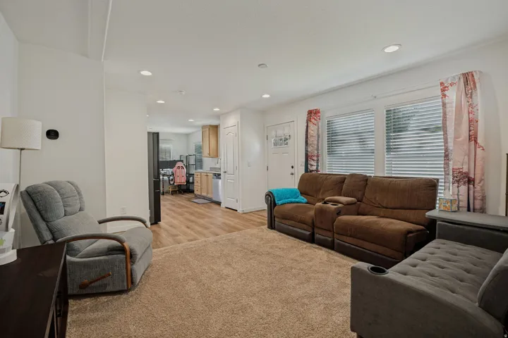 Open-concept living area featuring recessed lighting, wood-finish flooring, and a neutral color palette