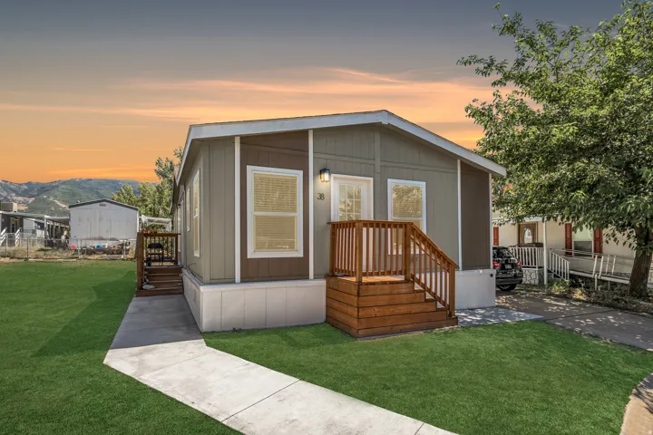 Exterior featuring two-tone siding, a wood-finish porch with railings, and a concrete walkway