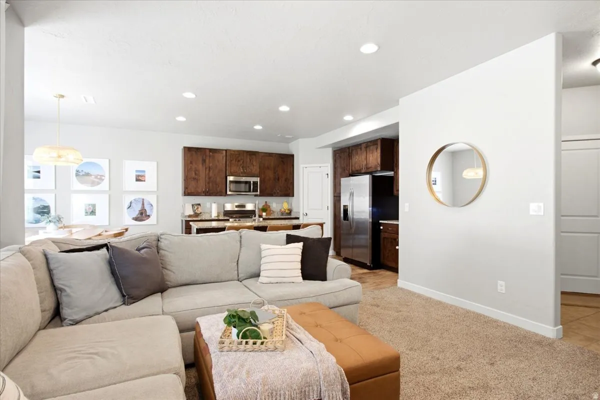 Recessed lighting, wood-finish cabinetry, stainless steel appliances, solid surface countertops, and carpeted flooring