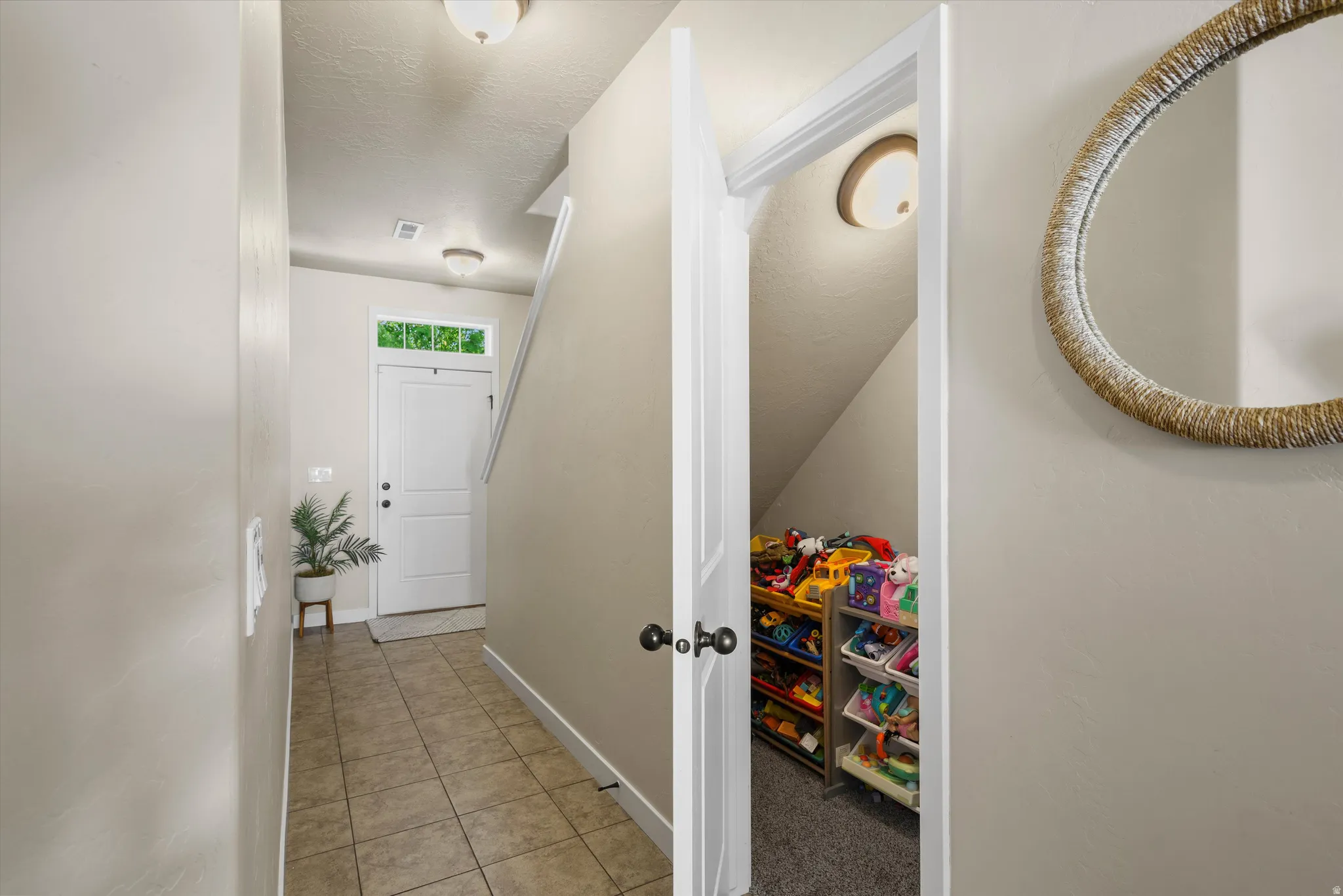 Foyer featuring tile flooring, a white paneled entry door with transom window, and flush mount lighting
