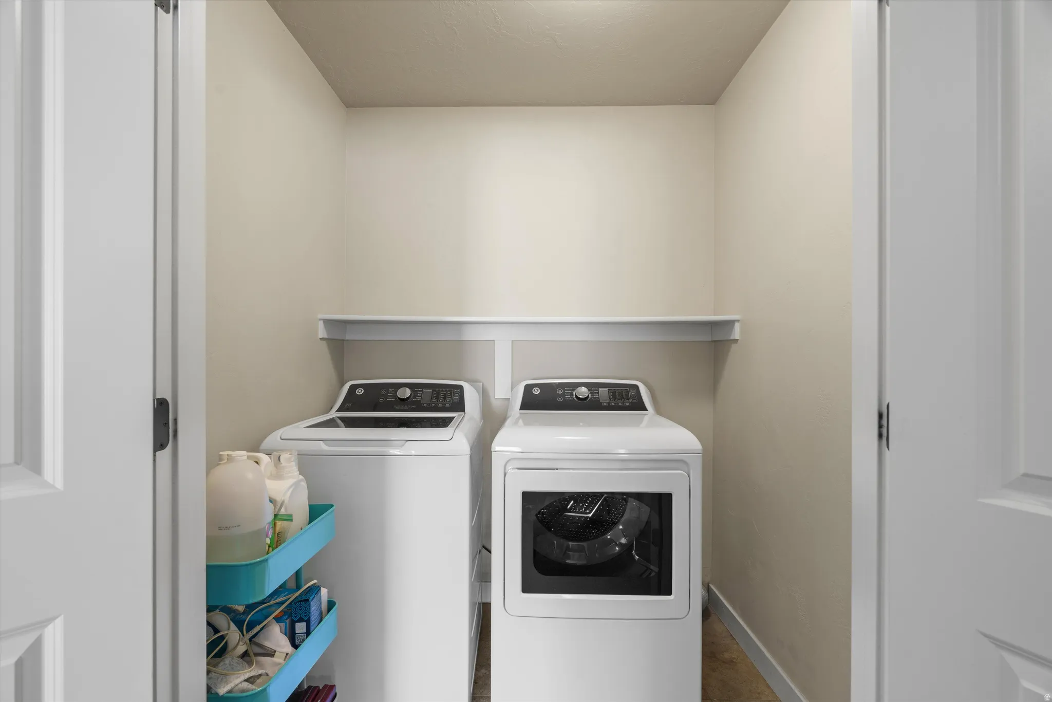 Laundry closet featuring a built-in shelf and light-colored walls