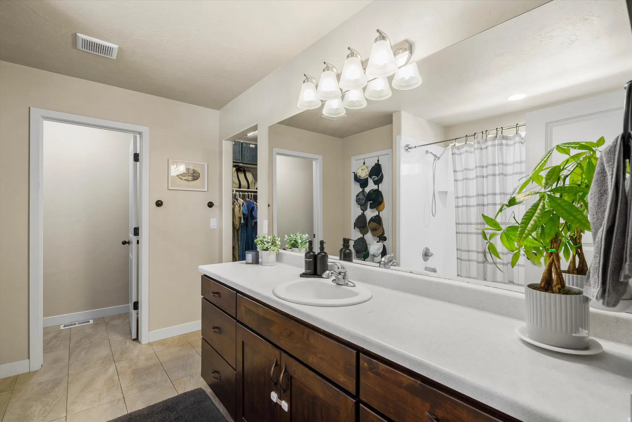 Spacious vanity with a white countertop and dark wood-finish cabinetry, featuring an integrated sink