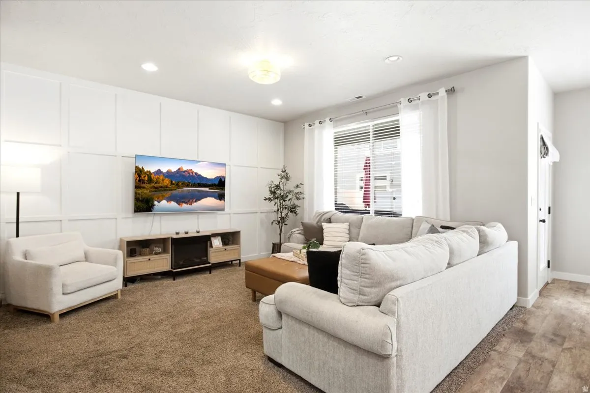 Feature wall with decorative paneling, recessed lighting, and a built-in media console