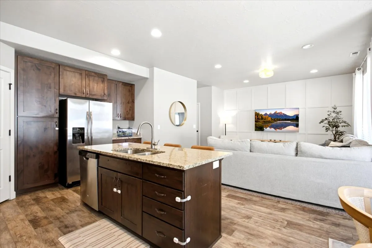 Kitchen island with a granite countertop, stainless steel sink, and gooseneck faucet