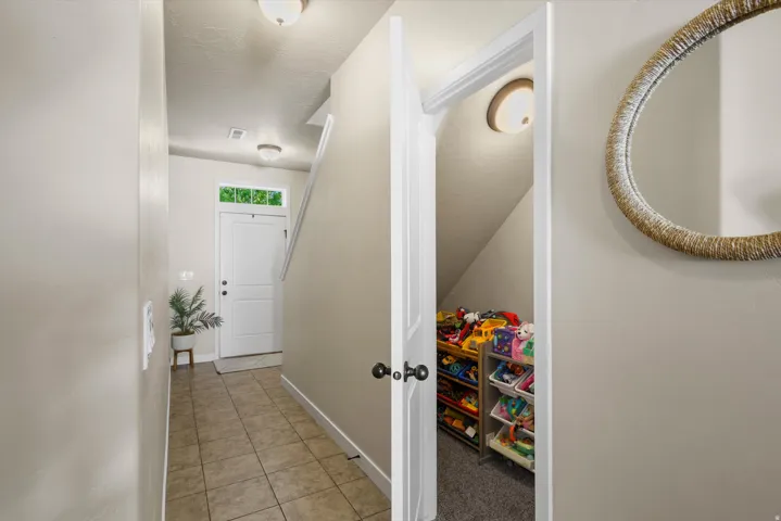 Foyer featuring tile flooring, a white paneled entry door with transom window, and flush mount lighting