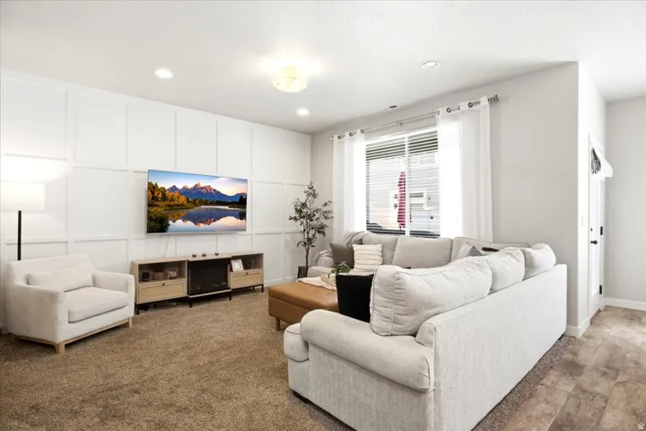 Feature wall with decorative paneling, recessed lighting, and a built-in media console