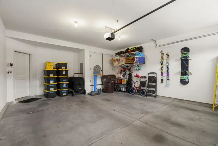 Garage featuring concrete flooring, white walls, and a built-in shelf system