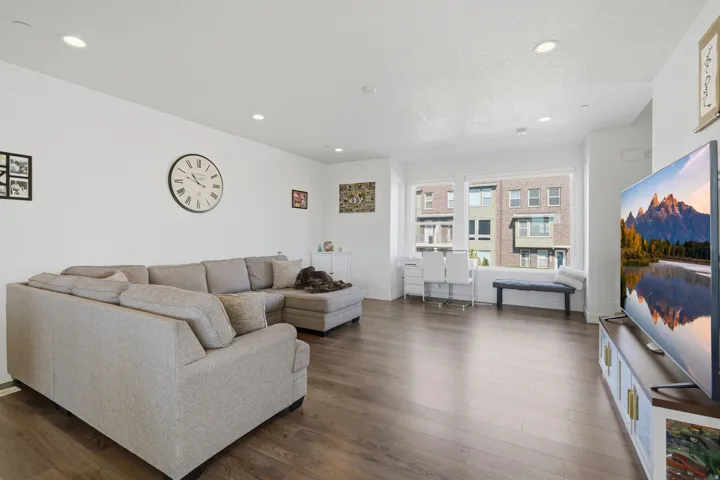 Recessed lighting, wood-finish flooring, white painted walls, and large windows