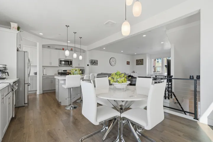 Open-concept kitchen and dining area featuring wood-finish flooring, recessed lighting, and a kitchen island with pendant lights