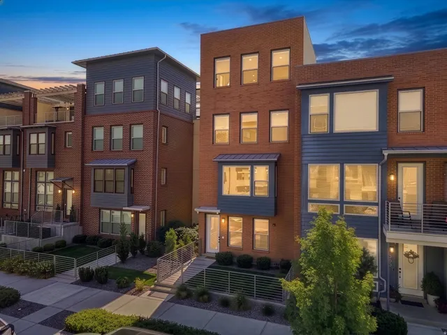Brick and siding exterior with multiple window styles, contemporary metal railings, and integrated landscaping