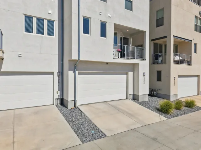 Private balconies, stucco exterior, integrated garage, concrete driveways, and modern exterior lighting