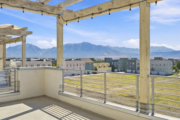 Rooftop deck featuring a wood pergola and string lighting
