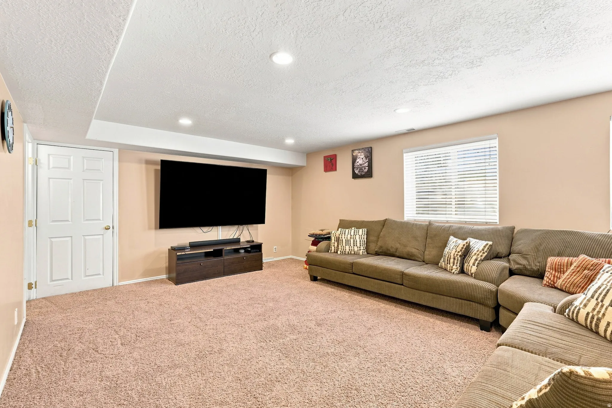 Recessed lighting illuminates this expansive carpeted area