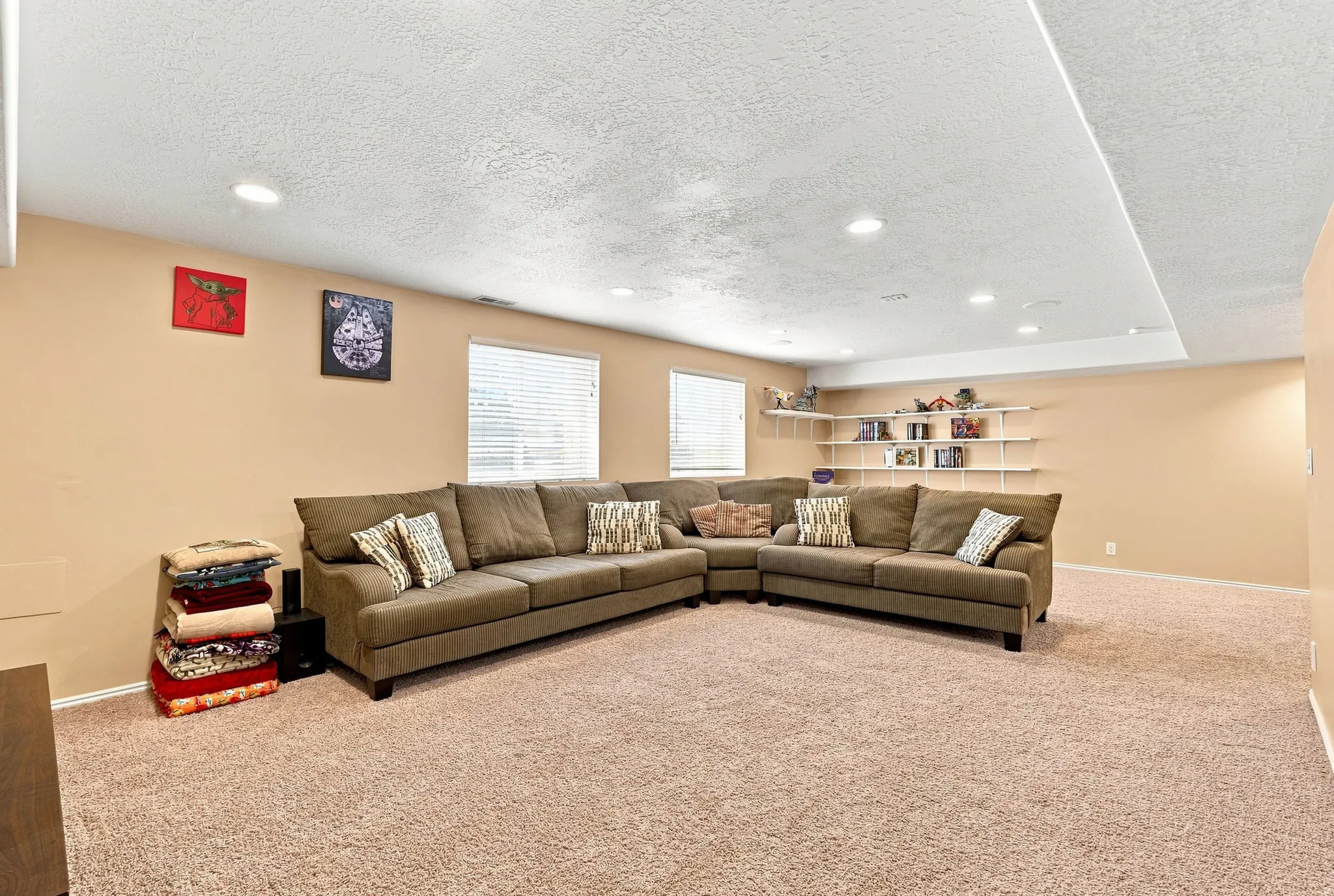 Recessed lighting illuminates the carpeted floor and built-in corner shelving