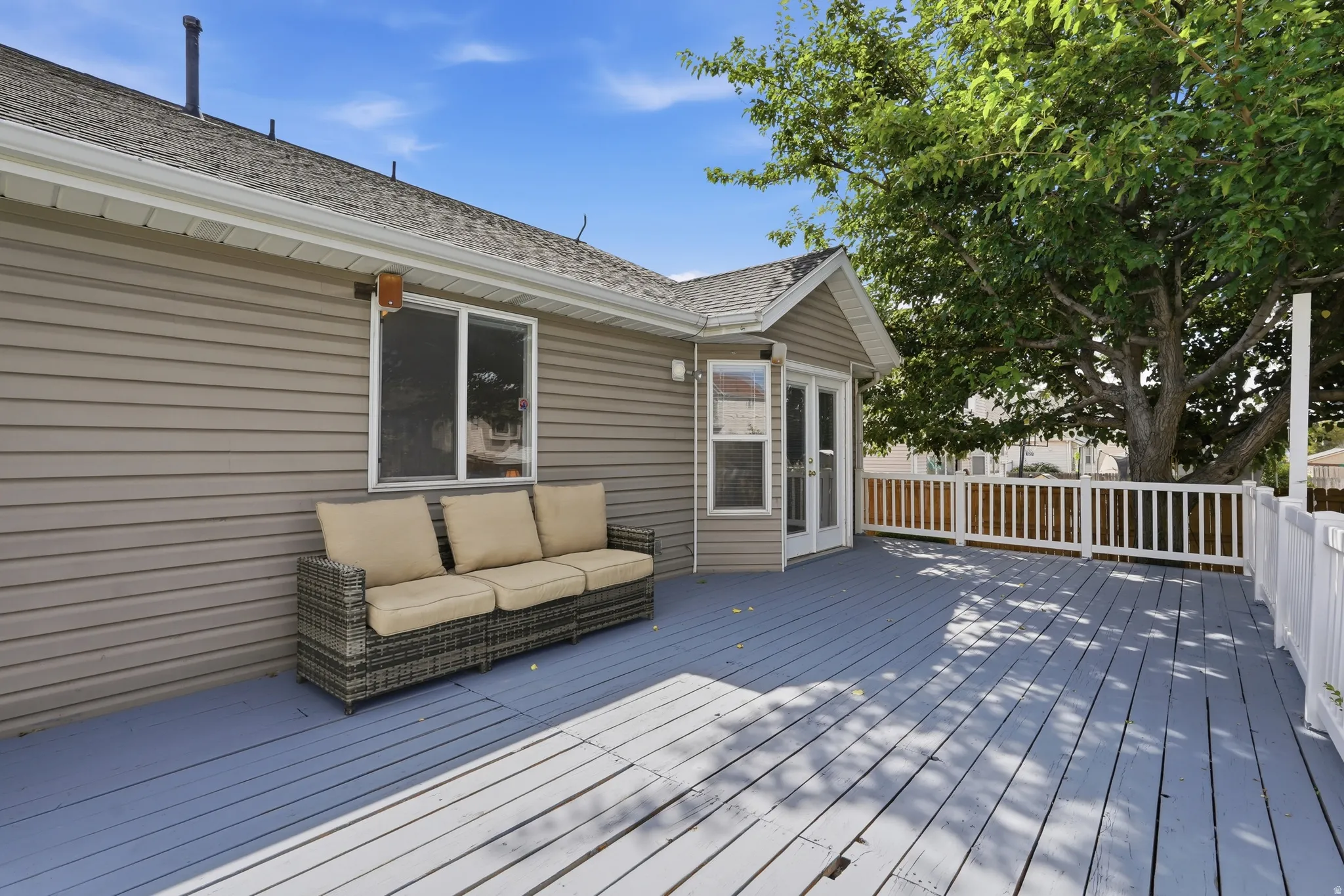 Expansive outdoor deck with painted wood flooring and white railing