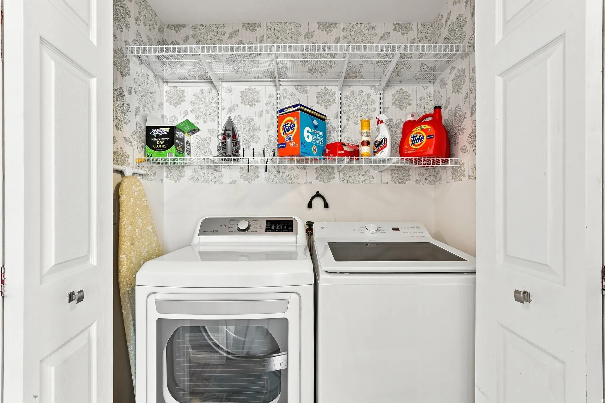 White bi-fold doors, wire shelving, and a patterned wall covering
