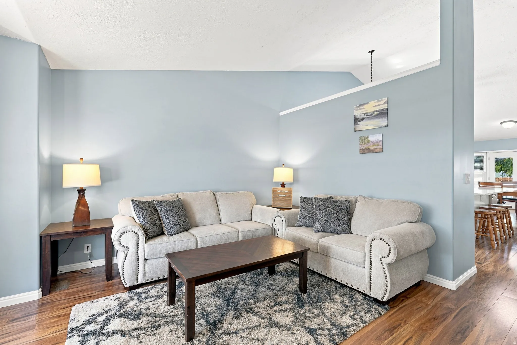 Vaulted ceilings, wood-finish flooring, half wall partition, painted accent walls