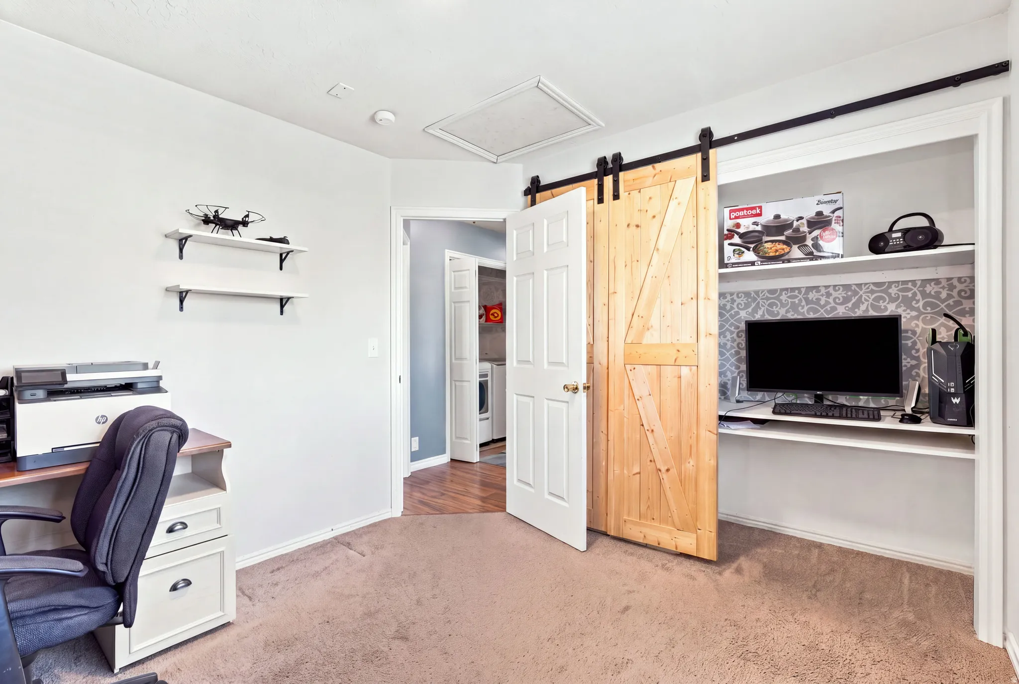 Integrated built-in desk, wood-finish barn door, and wall-mounted shelving